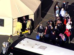 Captura de video que muestra a varios pasajeros abordando un autobús luego de desembarcar del crucero. AP/KGO-TV