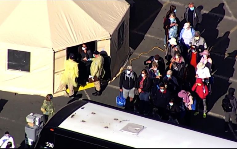 Captura de video que muestra a varios pasajeros abordando un autobús luego de desembarcar del crucero. AP/KGO-TV