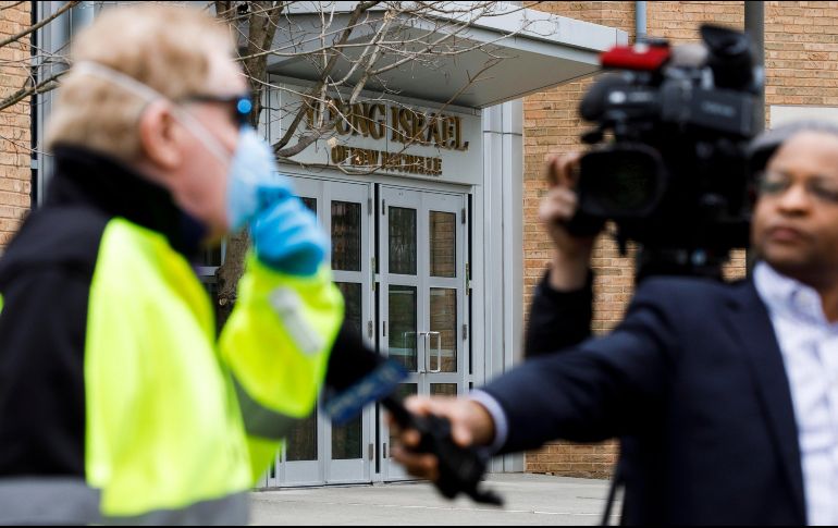 Nicholas Walsh (l), de New Rochelle, usa una máscara protectora mientras habla con reporteros fuera de la sinagoga Young Israel, en Nueva York. EFE/J. Lane