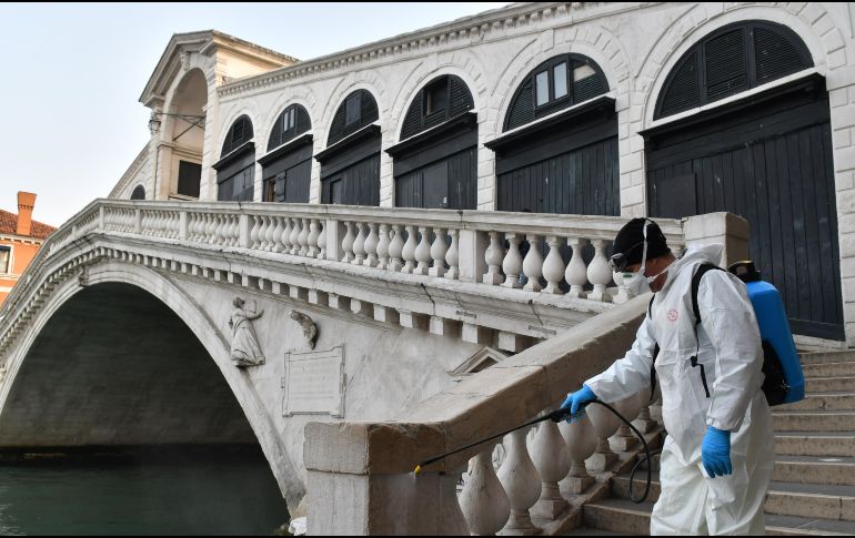 Un trabajador municipal rocía hoy desinfectante en el puente Rialto en Venecia. AFP/M. Sabadin