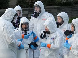 Trabajadores en atuendos protectores especiales se preparan para entrar a limpiar las instalaciones de un asilo de ancianos en Kirkland, Estados Unidos, donde se registró un brote de coronavirus. AP/T. Warren