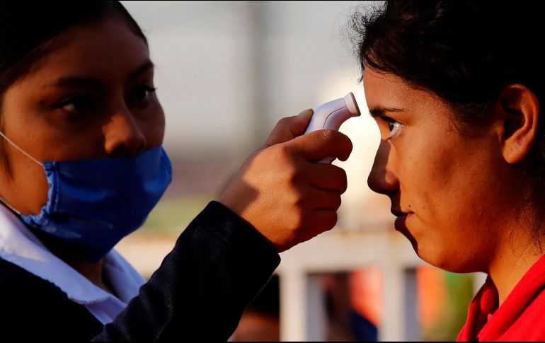 Una enfermera toma la temperatura como medida preventiva contra el Covid-19. AFP / U. Ruiz