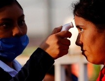 Una enfermera toma la temperatura como medida preventiva contra el Covid-19. AFP / U. Ruiz