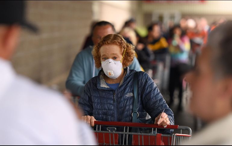 Varias personas hacen fila en un Costco de California; debido a la cuarentena, los habitantes compran toda clase de víveres para ya no salir de casa. AFP/J. Edelson