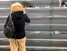 Una mujer junto a  anaqueles vacíos hoy en un supermercado en Buenos Aires. Habitantes realizan compras de pánico antre las medidas para contener el coronavirus. AFP/R. Schemidt