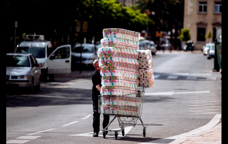 Un trabajador transporta rollos rumbo a un comercio en Málaga, España. EFE/J. Zapata