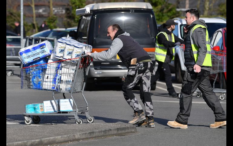 Un consumidor lleva papel del baño tras acudir hoy a un supermercado en Liverpool, Inglaterra. AFP/P. Ellis