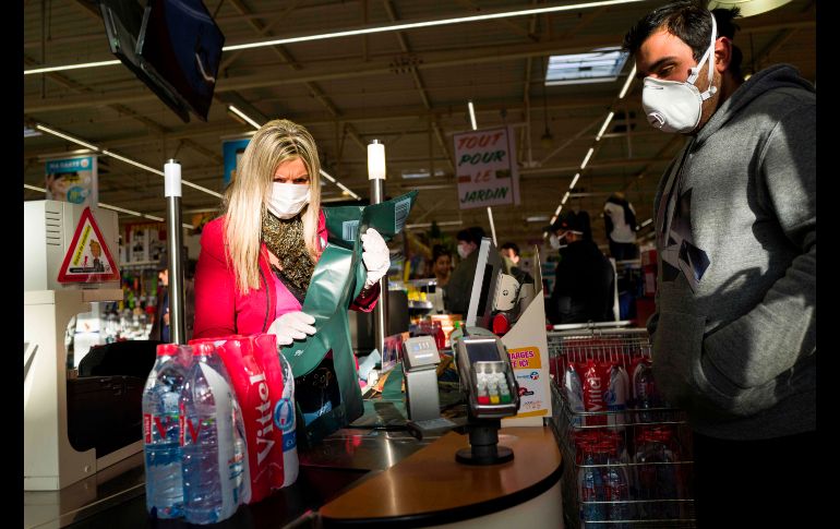 Aunque algunas cadenas de supermercados ya repartieron cubrebocas entre sus empleados, la medida de prevención no siempre se cumple. AFP/S. Bozon