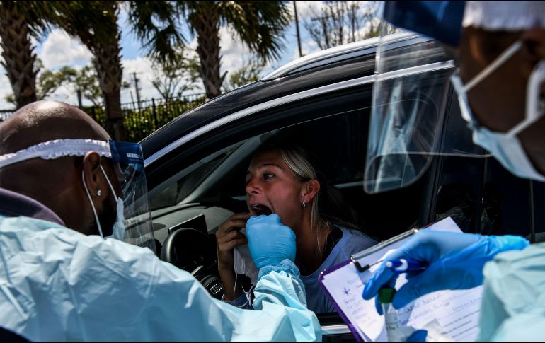 Personal médico toma muestras a una mujer en un laboratorio móvil en West Palm Beach, Florida, para que enfermos lleguen en sus vehículos (
