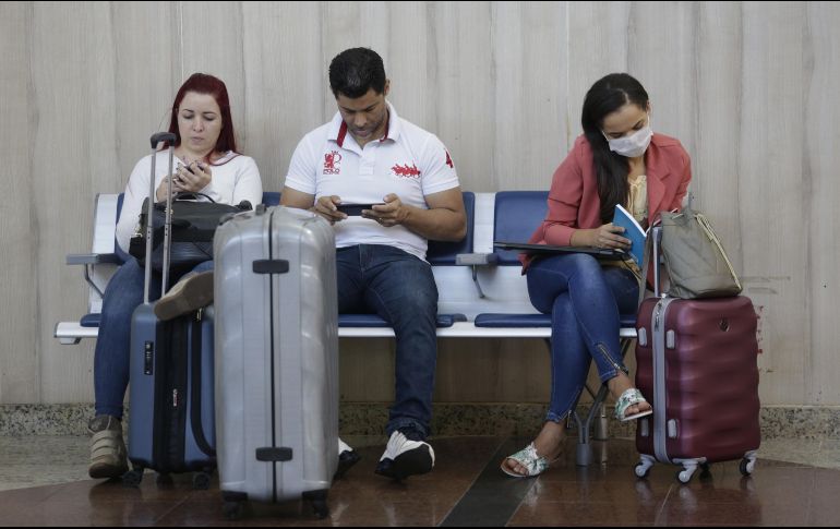 Pasajeros formados en las filas de los mostradores de aerolíneas buscan otras vías para llegar a sus países de origen. Xinhua / L. Tavora
