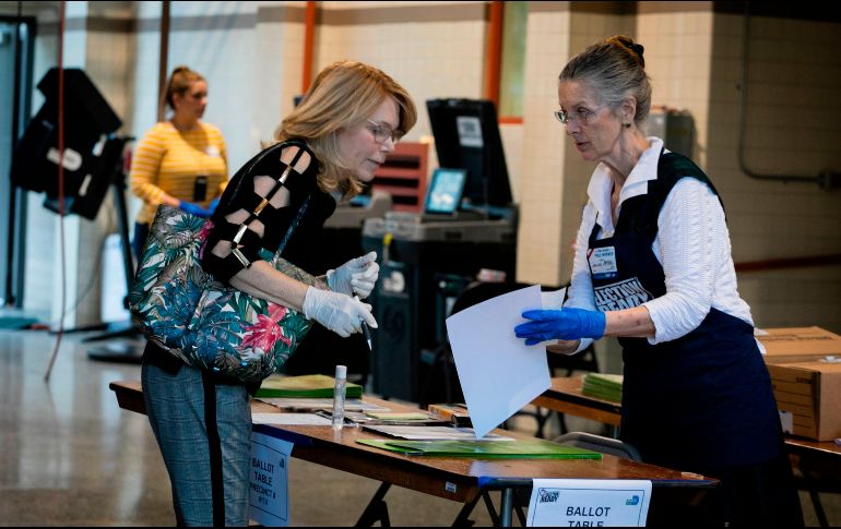 Una mujer con guantes acude a un centro de votación en Miami, Florida. AFP/E. Uzcategui