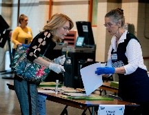 Una mujer con guantes acude a un centro de votación en Miami, Florida. AFP/E. Uzcategui
