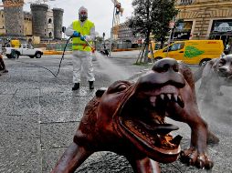 Un trabajador desinfecta una instalación del escultor chino Liu Ruowang en Nápoles, Italia. EFE/C. Fusco
