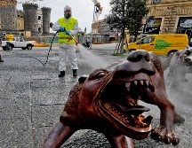 Un trabajador desinfecta una instalación del escultor chino Liu Ruowang en Nápoles, Italia. EFE/C. Fusco