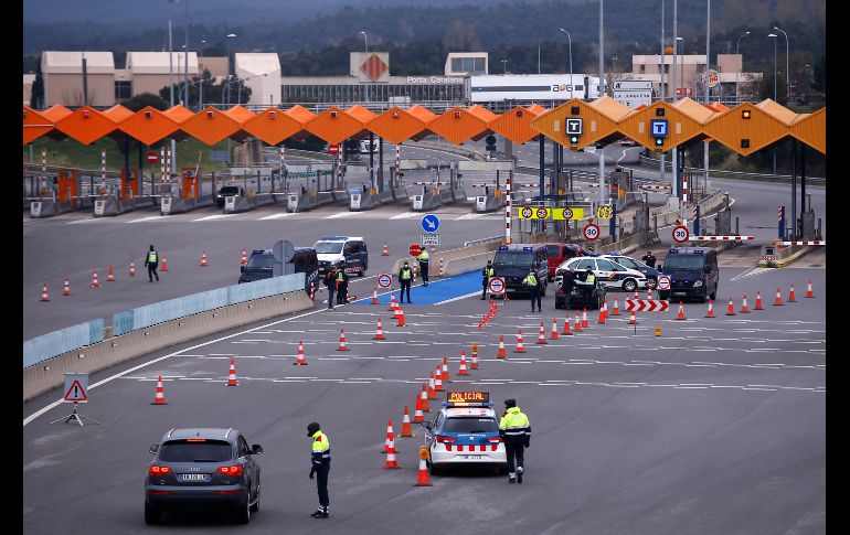 Policías en un punto de revisión en el cruce fronterizo de La Jonquera, entre España y Francia. Desde hoy, España solo permitirá el acceso al país a sus ciudadanos, residentes en España o a quienes acrediten fuerza mayor y al transporte de mercancías. AFP/P. Barrena