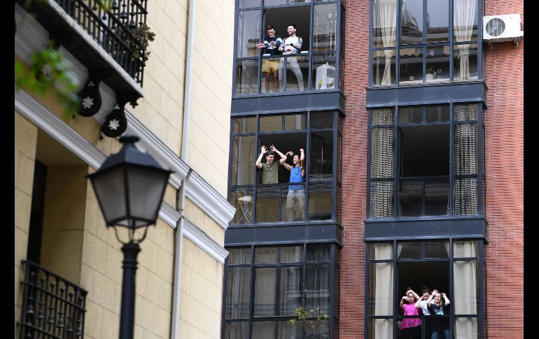 Personas confinadas en su casas bailan y cantan en Madrid, España. En el país se decretó el sábado el confinamiento casi general.  AFP/G. Bouys
