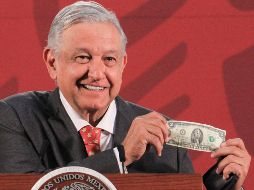 El Mandatario muestra un billete de dos dólares que le regaló un migrante. NTX / J. Lira