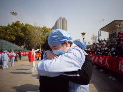 Un trabajador médico abraza a un miembro de un equipo de apoyo, en una ceremonia para despedir a los llegados de la provincia de Jiangsu para auxiliar con la emergencia del COVID-19 en Wuhan, China. AFP