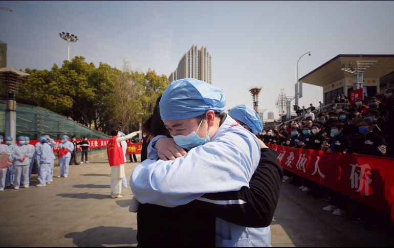 Un trabajador médico abraza a un miembro de un equipo de apoyo, en una ceremonia para despedir a los llegados de la provincia de Jiangsu para auxiliar con la emergencia del COVID-19 en Wuhan, China. AFP