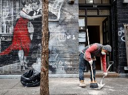 Un empleado cubierto por un tapabocas limpia las calles de Jueva York este jueves. AP/J. Minchillo