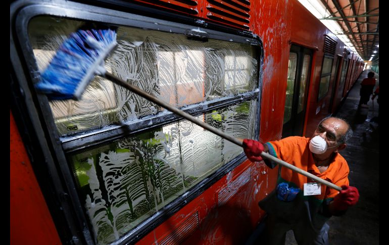 Un trabajador limpia la ventana de un tren del metro de Ciudad de México. AP/M. Ugarte