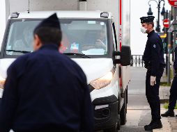 Oficiales franceses del CRS entrevistan a un camionero en Burdeos este jueves en medio de la cuarentena impuesta en el país. AFP/M. Fedouach