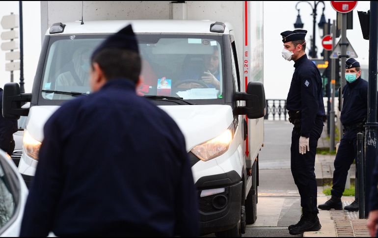 Oficiales franceses del CRS entrevistan a un camionero en Burdeos este jueves en medio de la cuarentena impuesta en el país. AFP/M. Fedouach