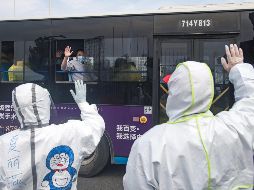 Pacientes curados a bordo de un autobús se despiden de trabajadores médicos en Wuhan, en la provincia de Hubei. XINHUA/X. Yijiu