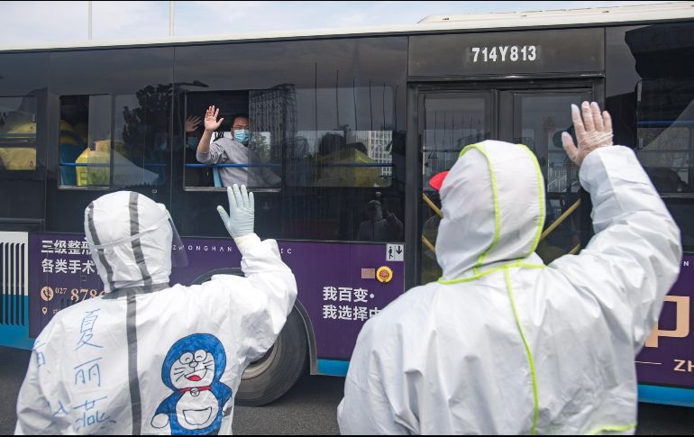 Pacientes curados a bordo de un autobús se despiden de trabajadores médicos en Wuhan, en la provincia de Hubei. XINHUA/X. Yijiu