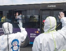 Pacientes curados a bordo de un autobús se despiden de trabajadores médicos en Wuhan, en la provincia de Hubei. XINHUA/X. Yijiu