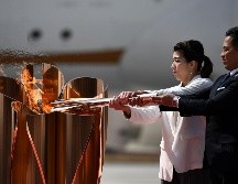 El fuego fue traspasado a un pebetero de color rosado con forma de flor, recordando a los cerezos que tiñen el paisaje japonés cada primavera. AFP / P. Fong
