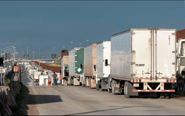 Camiones de carga hacen fila en Tijuana, Baja California, para cruzar hacia Estados Unidos. La restricción fronteriza no afecta el comercio. AFP/G. Arias