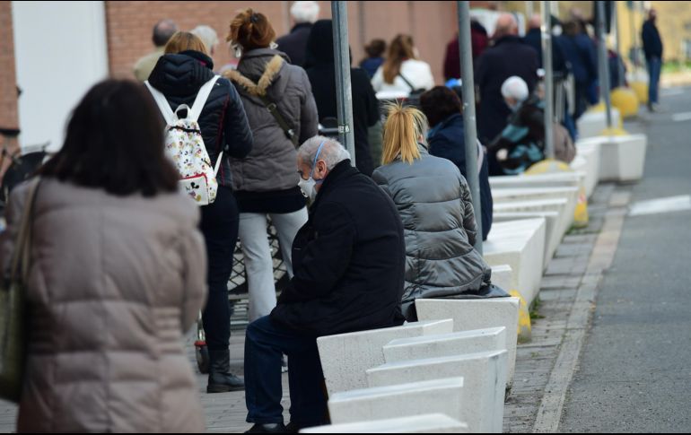 Varias personas esperan afuera de un supermercado en Boloña, Italia. XINHUA/G. Schicchi