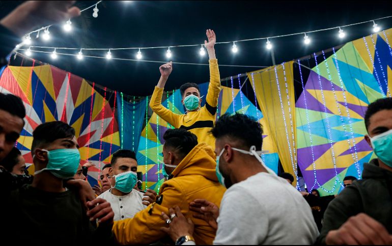 Varios muchachos palestinos, algunos con cubrebocas, bailan en unas festividades de boda en Rafah, en el sur de la Franja de Gaza. AFP/M. Hams