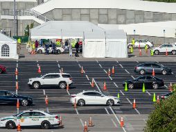 Conductores hacen fila para que les tomen muestras para pruebas de coronavirus en  el estacionamiento de un estadio en Miami, Florida. EFE/C. Herrera