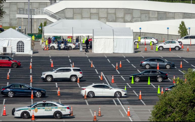 Conductores hacen fila para que les tomen muestras para pruebas de coronavirus en  el estacionamiento de un estadio en Miami, Florida. EFE/C. Herrera