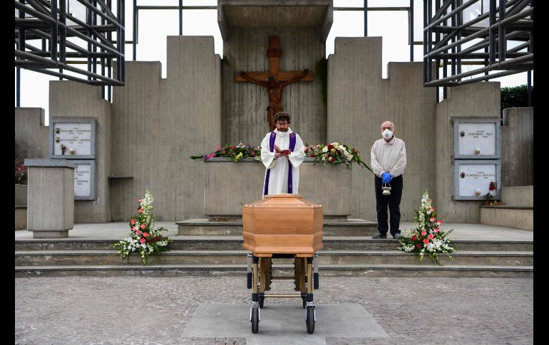 Un sacerdote realiza una ceremonia funeraria en un cementerio sin la presencia de familiares que están en cuarentena, en Grassobbio, en la región de Lombardía. AFP/P. Cruciatti