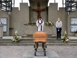 Un sacerdote realiza una ceremonia funeraria en un cementerio sin la presencia de familiares que están en cuarentena, en Grassobbio, en la región de Lombardía. AFP/P. Cruciatti