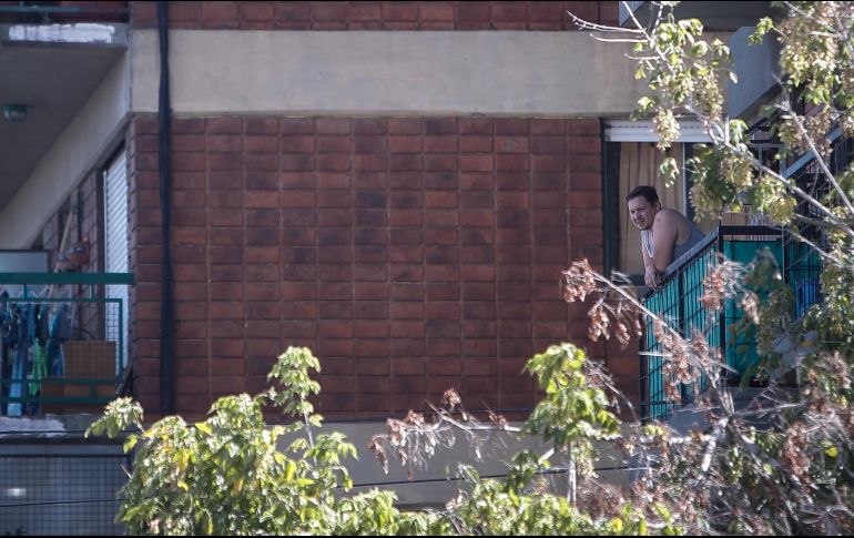 Un hombre mira desde su balcón mientras cumple el aislamiento obligatorio, en Buenos Aires, Argentina. EFE/J. Roncoroni