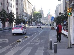 Vehículos circulan por una calle semidesierta del Centro Histórico de la Ciudad de México. XINHUA/S. Quintero