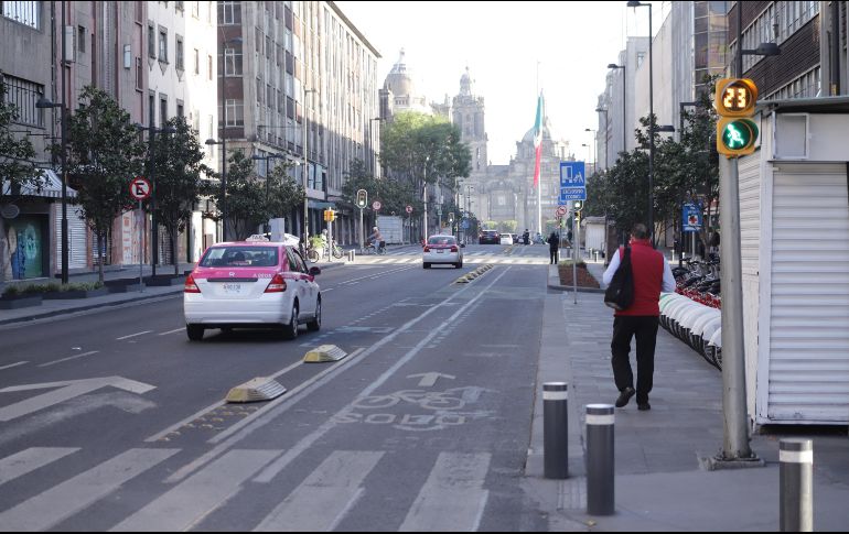 Vehículos circulan por una calle semidesierta del Centro Histórico de la Ciudad de México. XINHUA/S. Quintero
