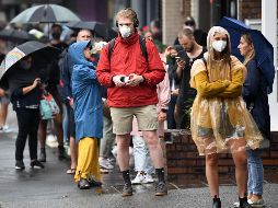 Varias personas protegidas con mascarillas caminan por calles de Australia. EFE/J. Carrett