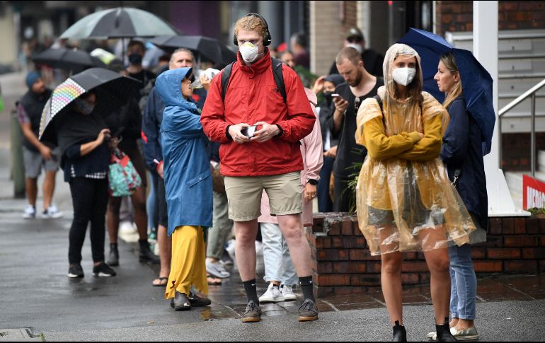 Varias personas protegidas con mascarillas caminan por calles de Australia. EFE/J. Carrett