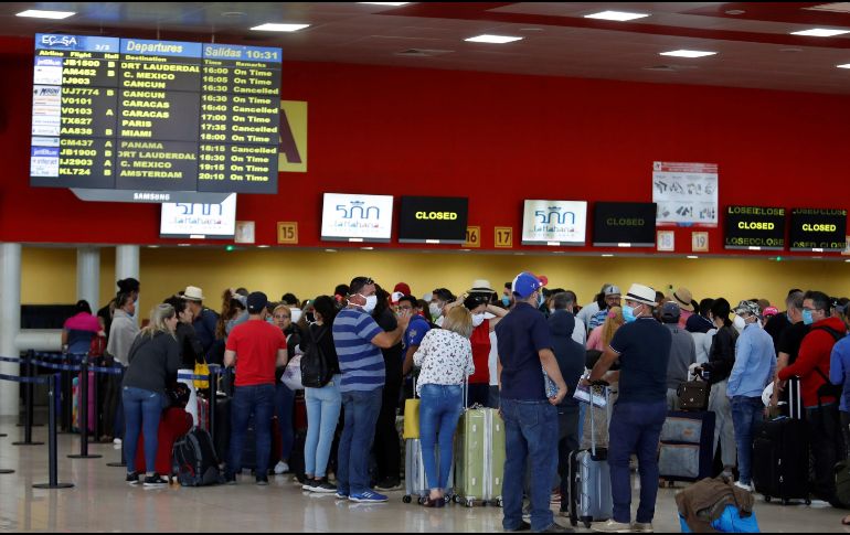 Varias personas esperan la salida de sus vuelos antes del cierre de las fronteras, este lunes, en el aeropuerto de La Habana. EFE/Y. Zamora