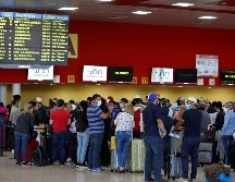 Varias personas esperan la salida de sus vuelos antes del cierre de las fronteras, este lunes, en el aeropuerto de La Habana. EFE/Y. Zamora