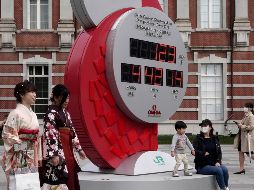 Ciudadanos japoneses pasan frente al reloj que señala los días y las horas que faltan para el arranque de la edición XXXII Juegos Olímpicos. EFE/K. Mayama