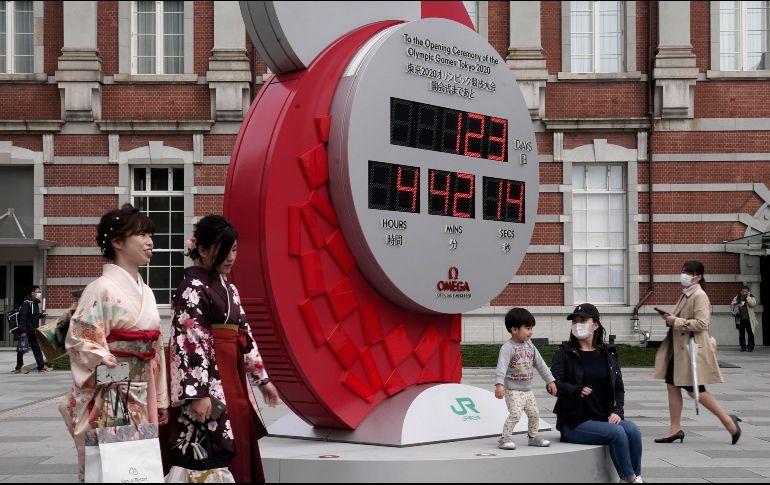 Ciudadanos japoneses pasan frente al reloj que señala los días y las horas que faltan para el arranque de la edición XXXII Juegos Olímpicos. EFE/K. Mayama