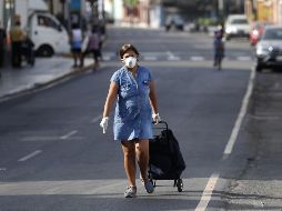 Una mujer camina con su carrito de compras por una avenida sin vehículos este martes, en Lima. EFE/P. Aguilar