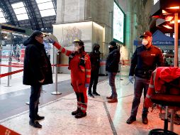 Un elemento de seguridad revisa la temperatura de un pasajero en la Estación Central de Milán. EFE/M. Balti