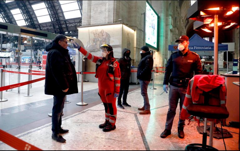 Un elemento de seguridad revisa la temperatura de un pasajero en la Estación Central de Milán. EFE/M. Balti
